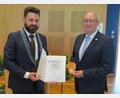 Bild: adj
Bürgermeister Sebastian Dippold (links) überreicht die Ernennungsurkunde und Medaille an Bernhard Knauer (rechts).
