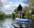 Symbolbild: Julian Stratenschulte/dpa
Ein junger Mann paddelt auf einem Stand-Up-Paddling-Board über einen Fluss.