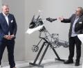 Bild: Hirsch
Geschäftsführender Gesellschafter Franz Schabmüller (links) und Pfarrer Martin Geistbeck (rechts) thematisierten bei der Einweihung der Welco-Halle die Oberflächenbehandlung von Motorradbauteilen.