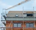 Symbolbild: Lino Mirgeler/dpa
Ein Baukran steht an einem neugebauten Haus. Auch in Plößberg lagen im Gemeinderat einige Bauanträge vor.
