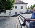 Bild: Stephan Huber
Georg Zunner sitzt auf der großen Freitreppe vor der Bergkirche, die irgendwann Mitte des 20. Jahrhunderts gebaut worden ist. Das alte Mesnerhaus im Hintergrund ist der Teil der Bergwirtschaft, der ein Denkmal ist. Es soll vollständig saniert und erweitert werden.