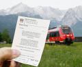 Symbolbild: Angelika Warmuth/dpa
Ein Mann hält ein 9-Euro-Ticket in der Hand, im Hintergrund fährt ein Zug der Deutschen Bahn.