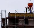 Symbolbild: Soeren Stache/dpa-zentralbild/dpa
Arbeiter stehen auf einer Baustelle eines Wohngebäudes.