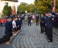 Bild: bnr
Auf Holzscheiten kniend bitten die Feuerwehrleute aus Glaubendorf die Nachbarwehr aus Woppenhof um die Übernahme der Ehrenpatenschaft.