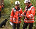 Bild: hcz
Die stellvertretende Weidener Staffelleiterin Nicole Liebeskind (von rechts) weist Metha Lahn aus Traunstein bei der "Trümmerprüfung" in das Szenario ein. Lahns schwarzer Labrador wartet derweil geduldig auf seinen Einsatz.