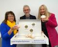 Bild: Völkl/exb
Im praktischen Karton verpackt werden die Krapfen am 11.11. ausgeliefert. Roman Sorgenfrei, Präsident der Lions Oberpfälzer Wald, Past-Präsidentin Maria Schlögl (links) und Renate Ahrens, Vizepräsidentin der Schwandorfer Lions (rechts), probieren schon mal.