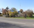 Bild: flt
Hinter dem Garten samt großem Kreuz befindet sich ein Kinderspielplatz, der von der Straße erst sehr spät zu erkennen ist. Von rechts kommen die Fahrzeuge, die von der B 15 nach Schönficht einfahren. Ein „Street-Buddy“ und ein Schild (Mitte) weisen auf spielende Kinder hin.