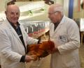Bild: dob
Preisrichter Georg Kellermann (links) und Josef Franz (rechts) attestieren einem Hahn der Rasse Hampshire goldbraun einen hervorragenden Rassestandard.