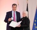 Bild: Bayerische Staatsregierung/Timm Schamberger/exb
Silvia Kromp bekommt das Ehrenzeichen von Markus Söder überreicht.