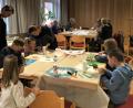 Bild: cro
Adventskerzenbasteln für Jung und Alt im Theresienheim. Pfarrer Georg Gierl schaut den Kindern beim Basteln der Kerzen über die Schulter.