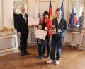 Bild: Regierung der Oberpfalz/Schmied/exb
Regierungspräsident Walter Jonas zeigt das Foto nach den Ehrungen mit Lebensretterin Steffi Günther (mit Sohn Paul) und Lebensretter Franz-Josef Heigl (von links).