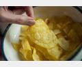 Symbolbild: Daniel Karmann/dpa
Eine Frau greift nach Kartoffelchips.