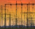 Symbolbild: Jens Wolf
Die untergehende Sonne verfärbt den Himmel hinter Hochspannungsleitungen. Wie sind Stromkonzerne auf einen Blackout vorbereitet?