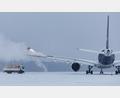 Symbolbild: Daniel Karmann/dpa
Erstmal enteisen: Winterwetter führt immer wieder zu Verzögerungen im Luftverkehr.