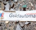 Bild: Patrick Pleul/zb/dpa
Splitter und ein Schild mit der Aufschrift „Geldautomat“ liegen auf dem Fußboden.