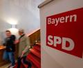 Symbolbild: Lino Mirgeler/dpa
Zwei Männer gehen am Logo der SPD Bayern vorbei. Der Umgang der Landeschefs mit dem Abgang von Taşdelen wirft kein gutes Licht auf die Partei, meint Jürgen Umlauft.