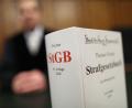 Bild: Oliver Berg/dpa
Ein Strafgesetzbuch (StGB) auf der Richterbank.