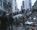 Bild: Uncredited/IHA/AP/dpa
Menschen und Rettungsteams versuchen, eingeschlossene Bewohner in eingestürzten Gebäuden zu erreichen.