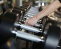 Bild: Oliver Berg/dpa/Symbolbild
Eine Frau nimmt in einem Fitnessstudio Hanteln aus dem Ständer.