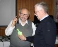Bild: Museumsfachstelle/exb
Der frühere Physiklehrer Rudolf Geipel aus Regenstauf (links) betrachtet mit Benno Krottenthaler, Betreuer der Museen im Rathaus Plößberg, ein unter UV-Licht fluoreszierendes Schnupftabak-Glasflakon aus Uranglas.