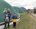 Bild: Portner
Landwirt Johannes Hösl steht mit seinen Söhnen Manuel und Christian (rechts) vor seinen vier Biogas-Behältern am Ortsrand von Hof. Die ersten Häuser der Stadt Oberviechtach sind ganz nah sowie auch Gewerbepark (rechts) und Krankenhaus.