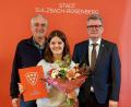 Bild: mfh
Das Schach-Talent Laura Sophie Bauer bekommt neben der Auszeichnung in Silber auch einen Sonderpreis. Mit im Bild ihr Trainer Ottmar Mühlberger (links) und Bürgermeister Michael Göth (rechts).
