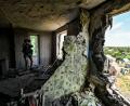 Archivbild: picture alliance/dpa/Ukrinform
Ein Journalist macht im Juni 2022 Fotos von den Folgen des russischen Beschusses von Häusern in der Region Saporischschja im Südosten der Ukraine.