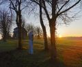 Bild: hzi
Am Horizont lugt die Morgensonne hervor; links verborgen hinter dem Baum der Aussichtsturm und daneben die Kalvarienbergkapelle.