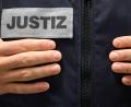 Symbolbild: Sebastian Gollnow/dpa
Ein Justizbeamter steht in einem Gerichtssaal.
