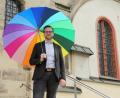 Bild: Wolfgang Steinbacher
Lucas Lobmeier setzt gerne subtile Botschaften, wie hier mit einem Regenbogen-Schirm vor der Pfarrkirche St. Marien in Sulzbach: „Den Schirm kann jeder deuten, wie er gerne möchte.“ Der Kaplan verlässt die Pfarrei in gut drei Monaten.