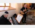 Bild: le
Pfarrer Wilfried Römischer (Gitarre und Gesang) und Kantor Andreas Kunz (E-Piano) bei ihren musikalischen Darbietungen, die der Feierstunde eine besondere Note verleihen.