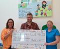 Bild: Fabian Lotter/exb
Katharina Ostermann (links) und Heike Kraft übergeben den symbolischen Scheck an Fabian Lotter, den Leiter der Kinderkrippe.
