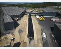 Bild: Wolfgang Erhart/exb
Auf Hochtouren laufen die Asphaltierungsarbeiten zwischen dem Kreisverkehr und der Bahnlinie. Links und rechts der Trasse der Umgehung stehen die Hallen des Fahrradherstellers Cube.