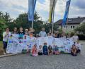 Bild: Gemeindebücherei/exb
Das Bücherei-Team übergibt Bürgermeister Thomas Meiler (Mitte) zusammen mit kleinen und großen Lesern und der Kindergartenleitung das Banner zum 1075. Geburtstag der Gemeinde.