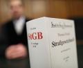 Symbolbild: Oliver Berg/dpa 
Ein Strafgesetzbuch (StGB) steht im Gericht auf der Richterbank: Gerichts-Reporter Wolfgang Houschka zweifelt die Taktik einiger Rechtsanwälte an.