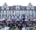 Bild: Armin Weigel/dpa
Besucher der Schlossfestspiele sitzen im Garten vor dem Fürstenschloss St. Emmeram.