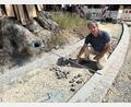Bild: Andreas Royer
Auch der große Baum in der Kurve der Bahnhofstraße gegenüber der Einfahrt zur Heinrich-Böll-Straße bleibt stehen. Planer Martin Dunst zeigt den dortigen Gehweg, der wie früher in einer Breite von 1,25 Meter daran vorbeiführt. Umgesetzt werden die Vorgaben von der Baufirma Englhard aus Amberg.