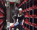 Bild: Sara Neidhardt
"WITRON"-Ingenieurin Anja Piehler vor einem "Crane", einem Regalfahrzeug, für das sie die Steuerung programmiert.