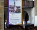 Bild: gac
Stadtpfarrer Herbert Mader (oben links) und Stadtpfarrer Roland Kurz (oben rechts) entrollen das Banner, das am Gerüst der Baustelle St. Marien aufgehängt wird und auf das Symposium hinweist.