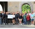 Bild: Dagmar Williamson 
Alexander Färber, Benjamin Färber und ihre Auszubildenden, das "Juniorteam" (rechts) übergeben 10.000 Euro an die Schweppermann-Stadtgruppe der KSJ Amberg und ihre Vorstände. Geplant für die Jubiläumsfeier ist auch eine Führung durch Innenleben des Ziegeltors, dem Hauptsitz ihres Treffpunktes.
