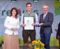 Bild: Hauke Seyfarth/StMELF
Staatsministerin Michaela Kaniber übergibt gemeinsam mit Hermann Berchtenbreiter, Präsident des Bayerischen Gärtnerei-Verbandes, den Meisterbrief an Christopher Hirteis (Mitte) aus Poppenricht (Zierpflanzenbau).