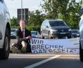 Symbolbild: Robert Michael, dpa
Sitzblockade der Protestgruppe „Letzte Generation“ an einer Autobahnabfahrt in Dresden. Der Aktivist trägt eine Maske mit dem Gesicht des Bundeskanzlers.