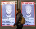 Bild: Peter Kneffel/dpa
Eine Frau geht am Ostbahnhof in München an einem digitalen Fahndungsplakat vorbei.