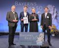 Bild: StMWi/Fotostudio Heuser/exb
Stellvertretend für das gesamte Team Matthes nahmen Isabella und Max Bayer den Mittelstandslöwen von Wirtschaftsstaatssekretär Roland Weigert (links) entgegen. Juror Marcus von Goldacker (rechts) gratulierte.