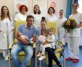 Bild: Kliniken Nordoberpfalz, Michael Reindl
Papa Flo hält den kleinen Max, Schwester Leni nimmt auf dem Schoss von Mama Nicole Platz als MUDr. Denisa Jungwirth, die Hebammen Ruth Mahal-Vollmayr und Julia Witt, Stationsleitung Elisabeth Luksch und ihre Stellvertreterin Anja Zeitlmann sowie Oberärztin Dr. Sophie Schultis (hinten, von links) der Familie gratulieren.