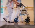 Symbolbild: Christoph Schmidt/dpa
Eine Pflegekraft begleitet eine Seniorin mit dem Rollator. Wie wollen Politiker den Spagat zwischen fairem Lohn und steigenden Heimkosten schaffen?