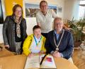 Bild: Stadt Schwandorf/exb
Alexander Harrieder trägt sich im Beisein seiner Eltern Brigitte und Peter Harrieder in das Goldene Buch der Stadt Schwandorf ein. Oberbürgermeister Andreas Feller gratuliert zum Team-Erfolg bei Special Olympics.