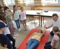 Bild: dob
Stellvertretender Bereitschaftsleiter Josef Solfrank machte die Teilnehmer des Kinderferienprogramms mit seiner Enkelin Lena (liegend) fit als Juniorhelfer.