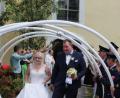 Bild: sis
Yvonne und Roland Schmid schreiten durch das Spalier, hinten links an der Kirchentür Peter Bublitz, Diakon und Vater der Braut.