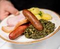 Bild: Hauke-Christian Dittrich/dpa
Saftig und deftig: Eine Portion Grünkohl mit den traditionellen Beilagen Salzkartoffeln, Kochwurst, Pinkelwurst und Kasseler - serviert in einem Oldenburger Restaurant.